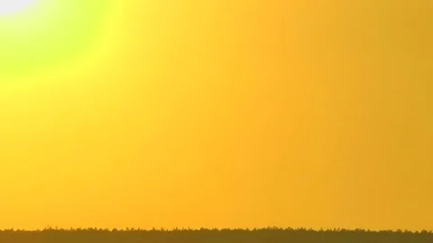 The hot fiery sun gradually growing dull slowly leaves for the horizon. Vidéo 70212391