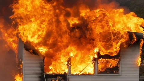 Hot flames rising as a small building is destroyed by a large fire. Slow motion Stock Footage 229817525