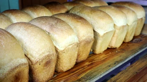 Hot freshly cooked bread is placed in trays in the bakery. Stock Footage 180457734
