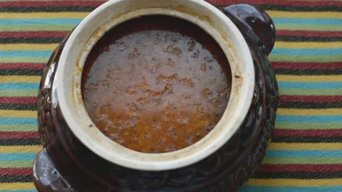Hot freshly cooked vegetable soup in a traditional ceramic pot Stock Footage 128819902