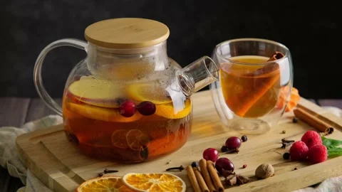 Hot fruit tea flavored with orange, cinnamon, berries and spice in transparent Stock Footage 223148295