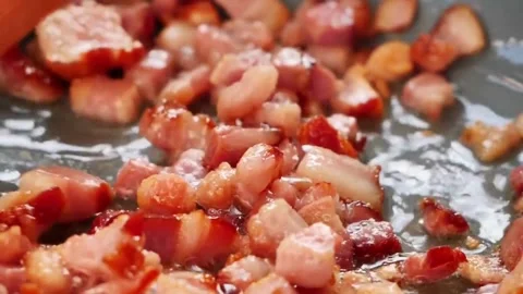 Hot frying pan with bacon meat chopped into small pieces. Fried bacon in pan. 스톡 동영상 334643480