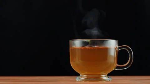 Hot green tea on black background. Freshly brewed citrus tea ceremony process Stock Footage 190883232
