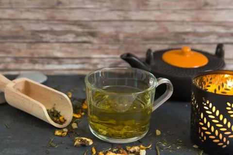 Hot green tea in cup composition with candle and tea pot Stock Photos