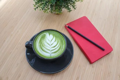 Hot greentea latte with red notebook Stock Photos