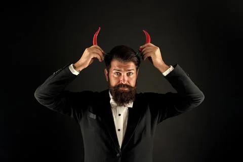 Hot as hell. Handsome macho likes spicy taste. Man hold pepper harvest. Red Foto stock