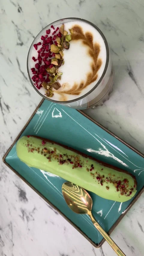 Hot lattes with foam Eclair with pistachios French pastry eclairs with pistachio Stock Footage 274211763