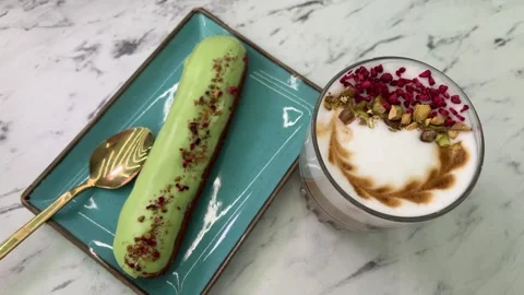 Hot lattes with foam Eclair with pistachios French pastry eclairs with pistachio Stock Footage 274211790