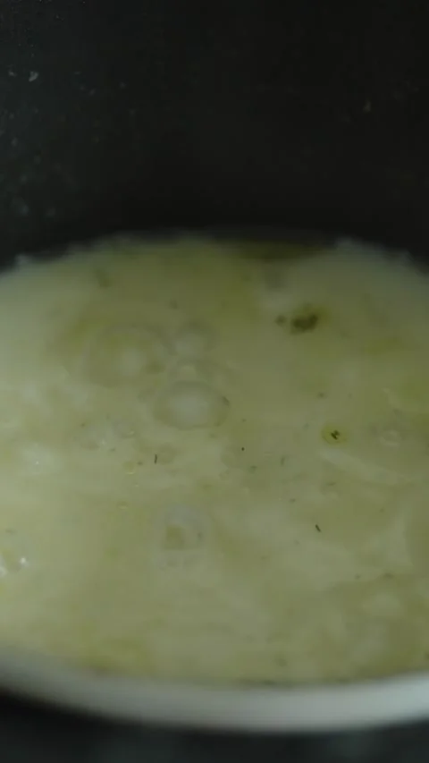Hot liquid mixture with potatoes bubbles gently inside a pot. Stock Footage 339210226