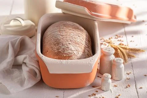 Hot loaf of bread baking in with grain and ears. Stock Photos