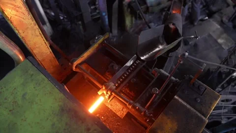 Hot metal bar glowing inside automated forging machine at industrial hand tool Stock Footage 336562930