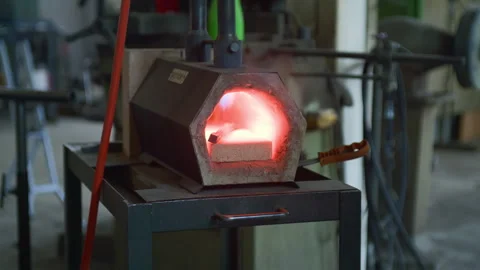 Hot Metal Inside Burning Forge – Blurred Blacksmith Workshop Behind Stock Footage 313850795
