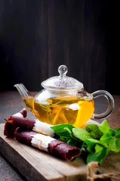 Hot mint tea in a tea pot and  dry fruits leather roll Stock-Fotos
