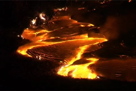 Hot molten lava slowly flows down a mountainside, through the Stock Footage