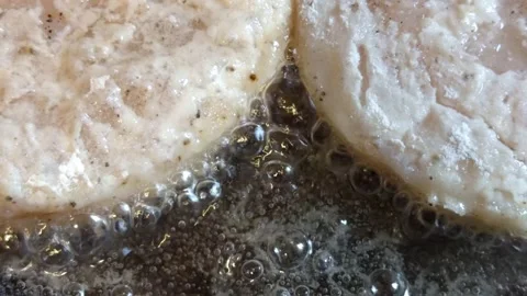 Hot oil bubbles around pieces of fillet during frying Stock Footage 343528456