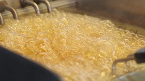 Hot oil frying process in a busy kitchen setting Stock Footage 329902297