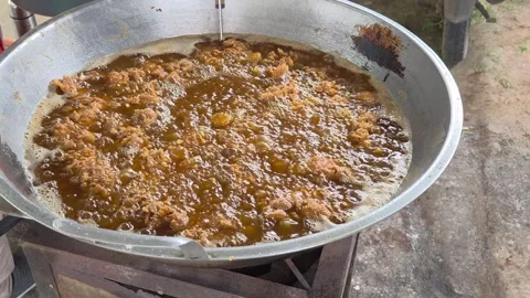 Hot oil vigorously bubbling while battered chicken cooks to a crunchy golde.. Vidéo 325693898