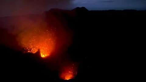 Hot orange magma is exploding out of the active crater and high into the air. Stock Footage 103233444