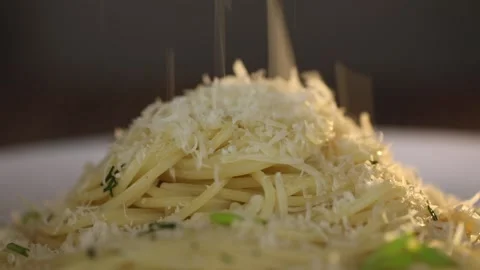 Hot pasta is sprinkled with grated cheese Stock Footage 167868356