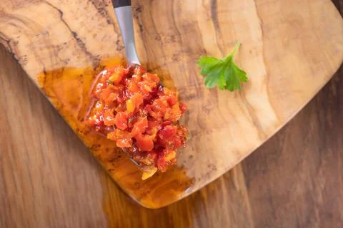 Hot paste made from chilli peppers and bell peppers with oil in a teaspoon 스톡 사진
