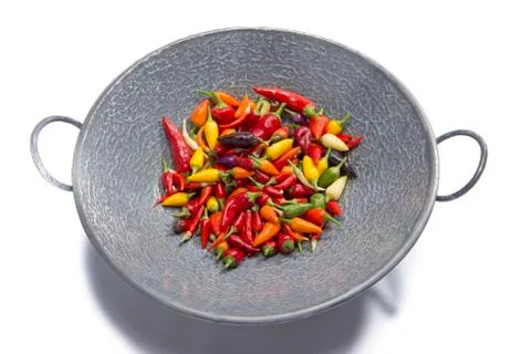 Hot peppers in wok pan Stock Photos