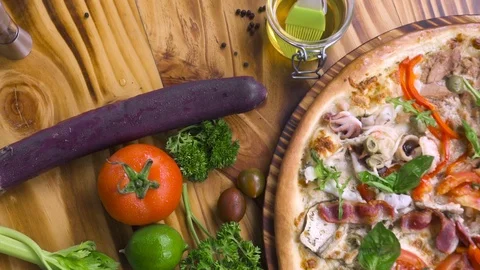 Hot pizza and fresh vegetable on wooden table background. Food background Stock Footage 104400510