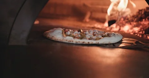 Hot pizza being cooked into an authentic brick oven Stock Footage 105309846