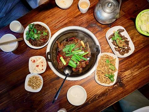 Hot Pot Feast with Assorted Side Dishes on Wooden Table Stock-Fotos