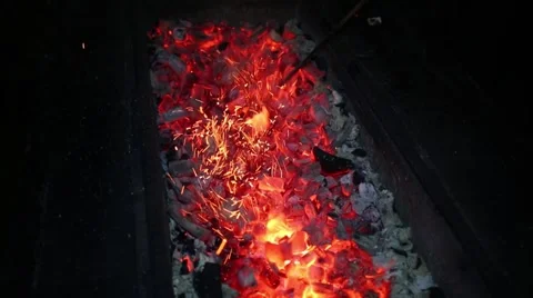 Hot red burning coals and hand moves it by poker at night Stock Footage 62149000