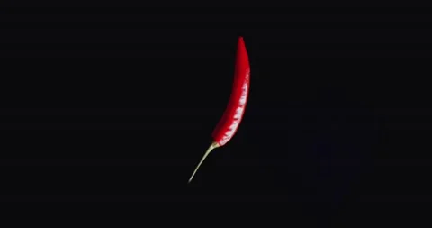 Hot red chilli pepper symbolically turm around on black background. Stock Footage 148400739
