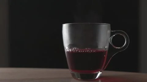 Hot Red Tea Being Poured Into Glass Cup in Slow Motion Stock Footage 328612644