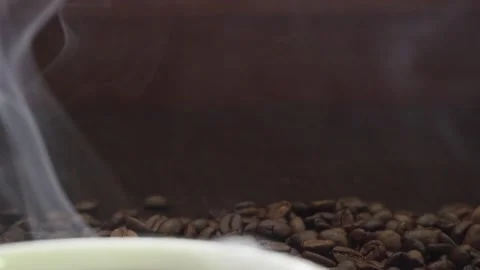 Hot roasted coffee beans had a soft smoke drifing behind a coffee cup, slowl Stock Footage 182471630