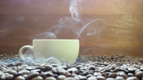 Hot roasted coffee beans have a smoky background in a coffee cup Stock Footage 182471894