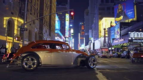 Hot rod cars on the New York City streets, illuminated Times Square cityscape Stock Footage