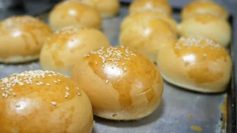 Hot round buns cooking on a flat tray indoors in a restaurant kitchen Stock-Footage 135231202