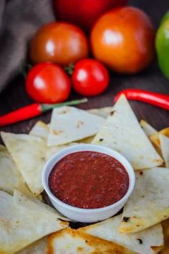 Hot salsa dip over the hip of nachos chips - organic home made sauce. Stock Photos