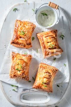 Hot sausage in puff pastry with tatar sauce and herbs Stock Photos