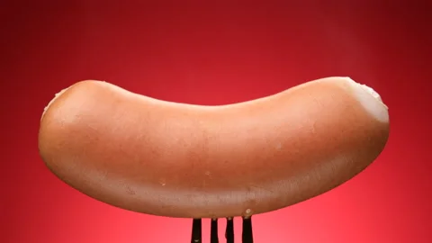 Hot sausages on fork, red background. 4K UHD video Stock Footage 164728380