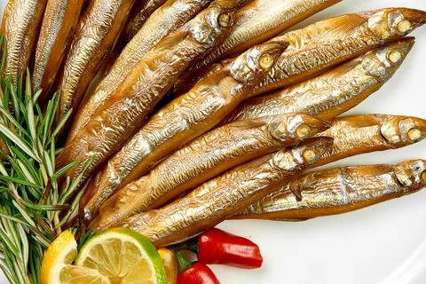 Hot-smoked fish in a plate on a white background. Close-up. Selective focus Stock Photos