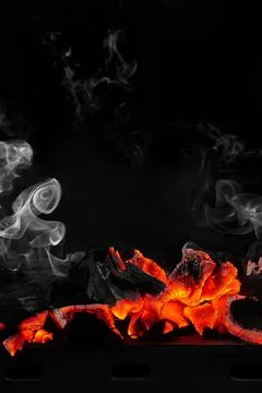 Hot smouldering charcoals on bbq grill on black background with white smoke Stock Photos