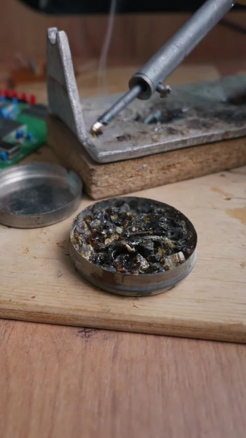 Hot Soldering Iron Tip Dipping Into Rosin Flux Tin for Cleaning Stock Footage 338331282