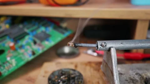 Hot Soldering Iron Tip Melting Rosin Near Green Circuit Board Stock Footage 338331114