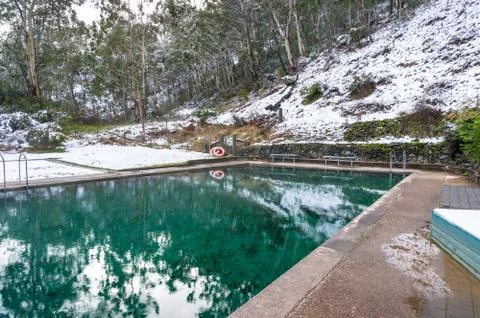 Hot spring pool with crystal clear water and snow covered ground nearby Stock Photos