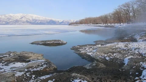 Hot spring steam drifting over sandy lake beach in winter, Japan Stock Footage 245041408