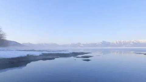 Hot spring steam drifting over calm caldera lake water Stock Footage 245041504