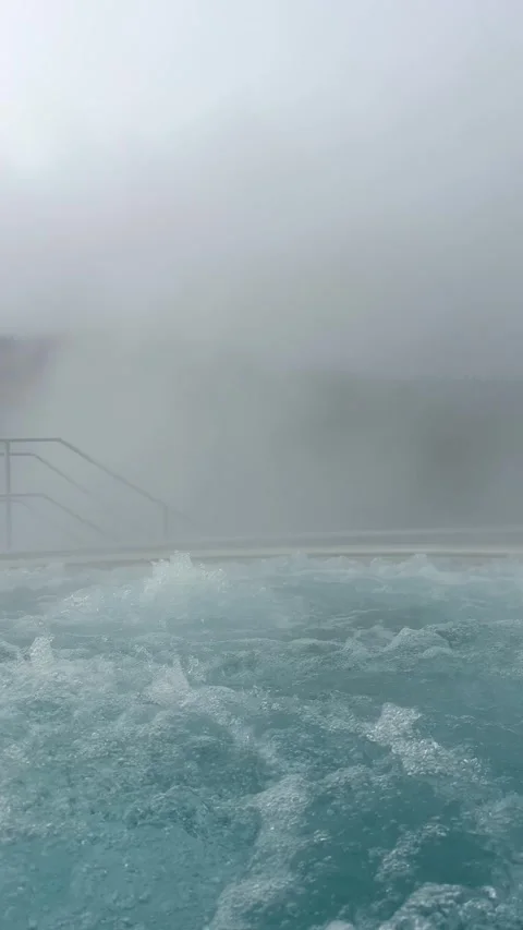 Hot spring water bubbling in a thermal pool on a foggy day Stock Footage 307227898