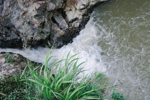 Hot spring water flows out from the rocks on the mountain Stock Photos