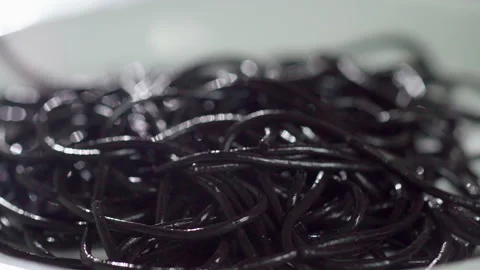 Hot Squid ink spaghetti drop to white plate slow motion Vídeos de archivo 158525268