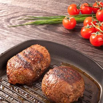 Hot steaks on pan Stock Photos