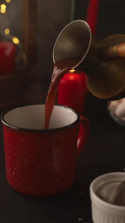 Hot steaming cocoa is poured into a red mug from turkey. Stock Footage